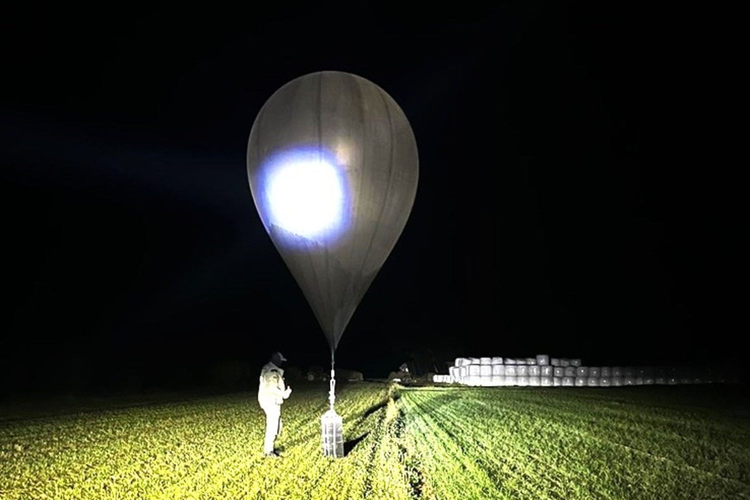 En litauisk grensevakt inspiserer en ballong som er brukt til å smugle sigaretter inn i landet fra Belarus.