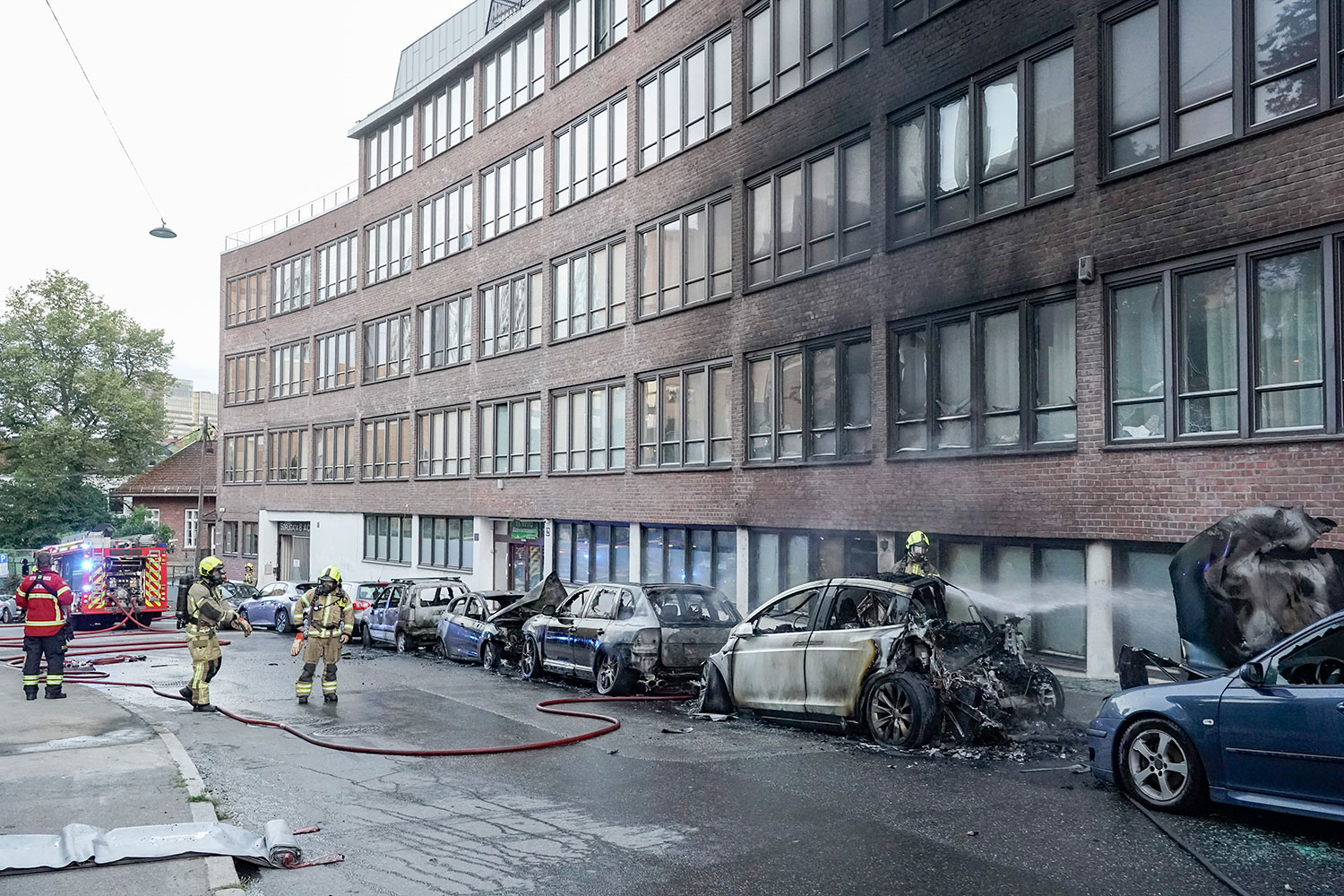 Flere biler ble trolig påtent i Sørligata på Grønland fredag morgen. Brannen spredde seg til en bygning på stedet.