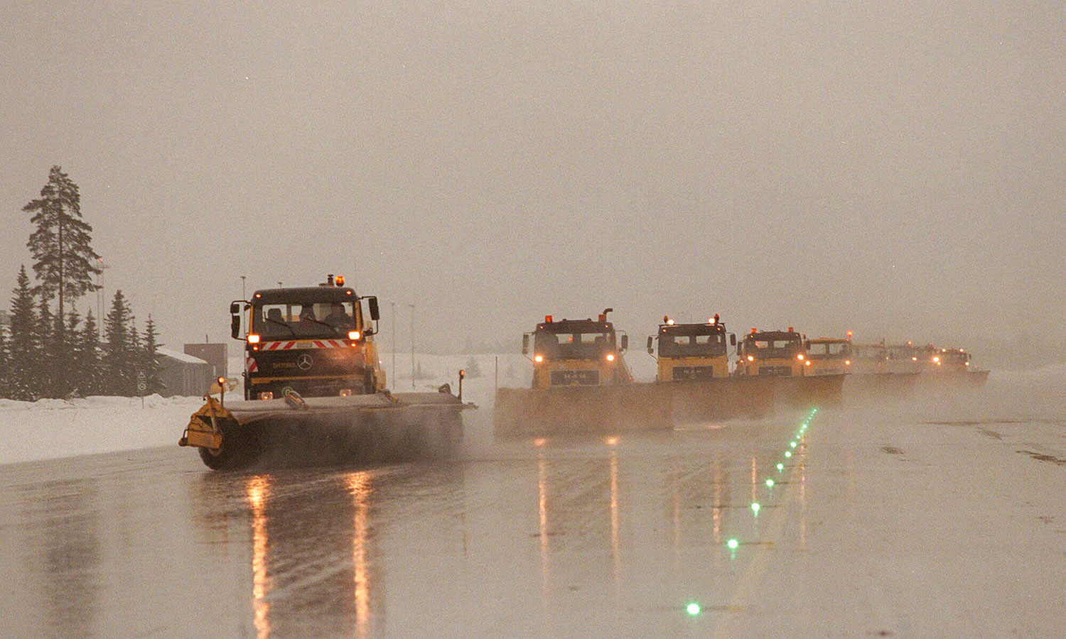 Brøytebiler rydder taxebanen på Oslo lufthavn Gardermoen for snø og is. Fra neste vinter skal bare den første bilen i rekken ha fører om bord. Resten skal være selvgående.