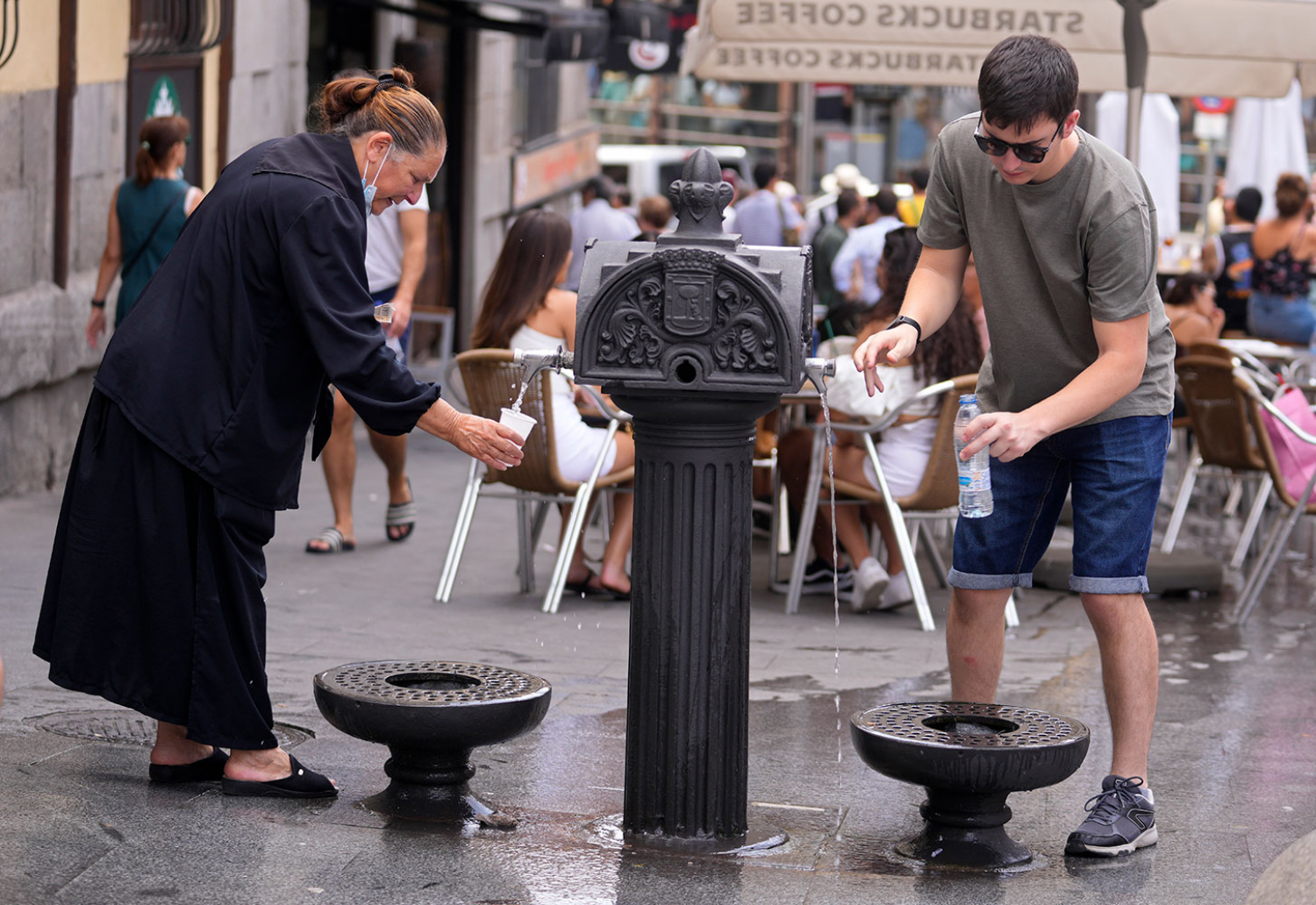 Både Spania og Frankrike opplever unormalt høye temperaturer. Her drikker folk i Madrid fra en fontene.