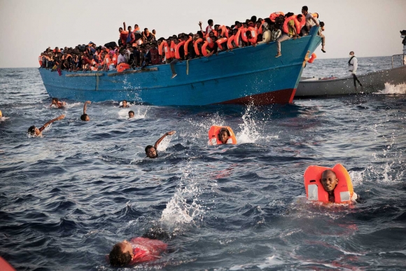 Arkivfoto fra 2016. Migranter, de fleste fra Eritrea, hopper i vannet under en redningsoperasjon i Middelhavet utenfor kysten av Libya.