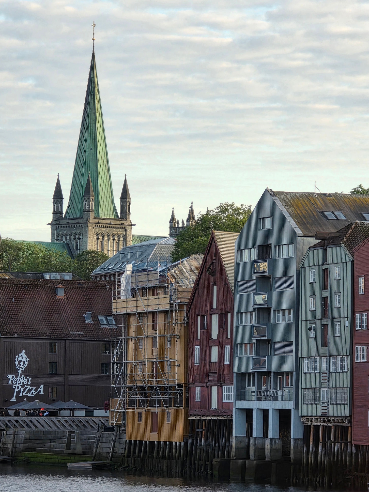 Den mektige Nidarosdomen ruver i bakgrunnen med de karakteristiske bryggene langs Nidelva i forgrunnen.