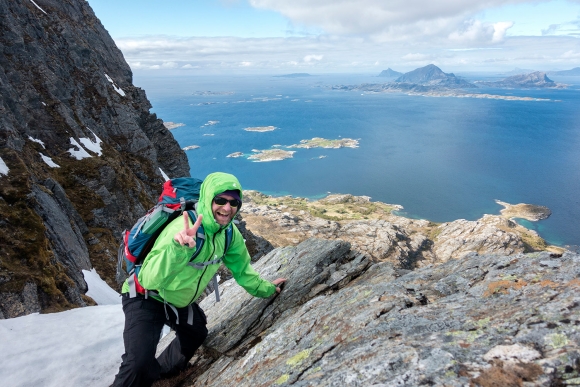 Nordmenn er nummer tre på lista over de lykkeligste i verden. Denne mannen er på tur opp på Tomskjevelen på Helgelandskysten. Bak i bildet Lurøya, Stigen og Hestmona.